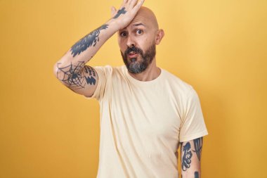 Sarı arka planda dikilen İspanyol dövmeli bir adam hata yaptığı için şaşırdı. Hatayı hatırla. Unuttum, kötü hafıza kavramı. 