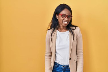 Gözlüklü Afrikalı genç bir kadın kameraya seksi bir ifadeyle bakıyor, neşeli ve mutlu bir yüzle.. 