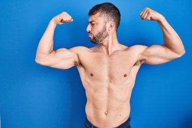 Yakışıklı İspanyol adam üstsüz duruyor ve gururla gülümsüyor. fitness konsepti. 