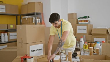 Genç İspanyol gönüllü hayır kurumunda bağış kutuları paketliyor.