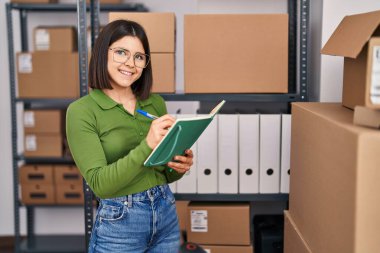 Genç, güzel, İspanyol bir kadın. İş kadını. Ofisteki deftere yazıyor.