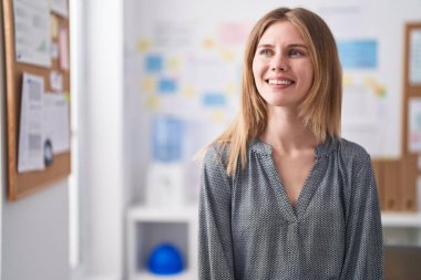 Ofiste kendine güvenen genç sarışın iş kadını gülümsemesi.