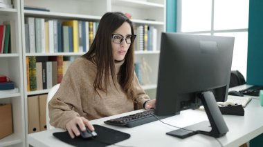 Güzel İspanyol kadın öğrenci kütüphane üniversitesinde bilgisayar kullanıyor.