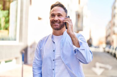 Kafkasyalı genç adam gülümsüyor. Kendine güvenen caddedeki akıllı telefondan konuşuyor.