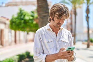 Young man using smartphone at street