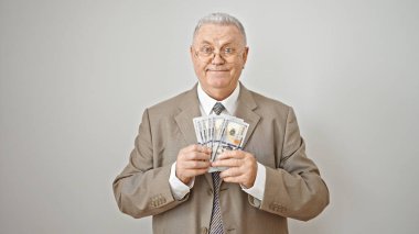 Orta yaşlı, gri saçlı iş adamı. Elinde dolarlarla soyutlanmış beyaz arka planda gülümsüyor.