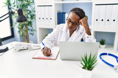 Afrikalı Amerikalı kadın doktor klinikteki belgeye yazı yazmanın altını çizdi