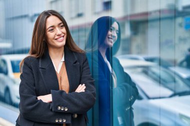 Sokakta kollarını kavuşturmuş genç, güzel İspanyol bir kadın.