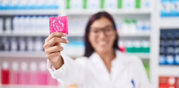 Young Beautiful Hispanic Woman Pharmacist Smiling Confident Holding Condom Pharmacy — Stock Photo, Image