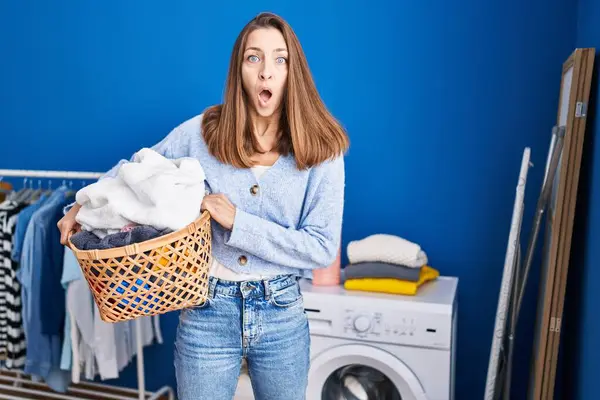 Ung Kvinna Som Håller Tvättkorg Rädd Och Förvånad Med Öppen — Stockfoto