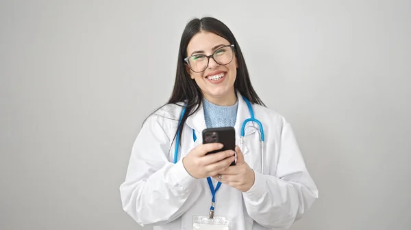 年轻的惊慌失措的女医生在孤独的白色背景下 用智能手机微笑 — 图库照片