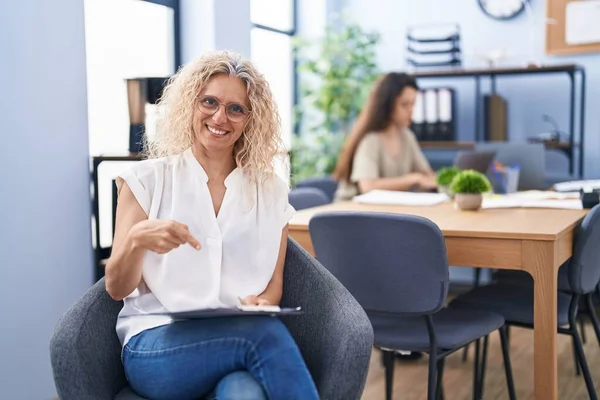 Mujer Mediana Edad Trabajando Oficina Sosteniendo Portapapeles Sonriendo Feliz Señalando — Foto de Stock