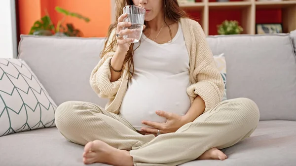 Mladá Těhotná Žena Pití Vody Masáže Břicho Doma — Stock fotografie