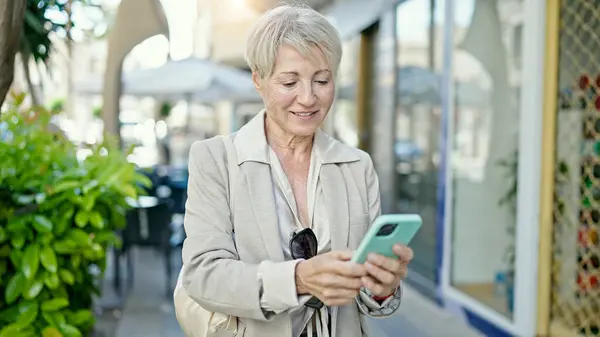 Blonde Frau Mittleren Alters Lächelt Selbstbewusst Mit Smartphone Auf Der — Stockfoto