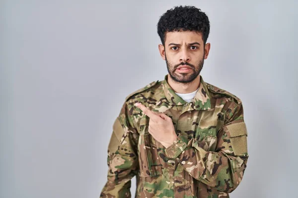 Arab Man Wearing Camouflage Army Uniform Pointing Aside Worried Nervous — Stock Photo, Image