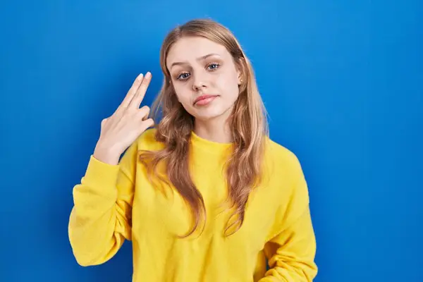 Kafkasyalı Genç Bir Kadın Mavi Arka Planda Durup Kendini Parmaklarını — Stok fotoğraf