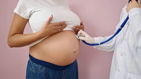 Mladá Těhotná Žena Lékařským Vyšetřením Stetoskopem Přes Izolované Růžové Pozadí — Stock fotografie