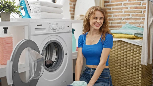 若い女性は洗濯室で自信を持って洗濯服を笑って — ストック写真