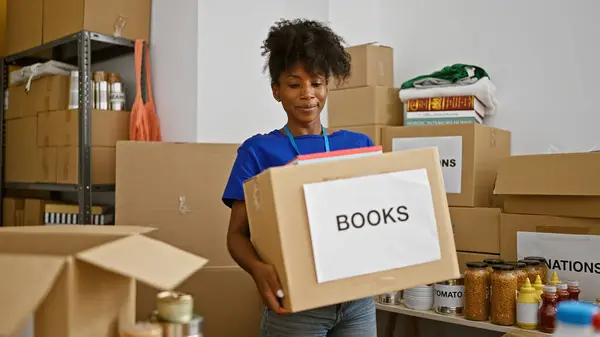 African American Woman Volunteer Holding Books Donation Package Charity Center — Stock Photo, Image