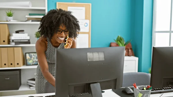 非洲裔美国女商人在办公室用电脑用智能手机交谈 — 图库照片
