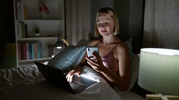 Mujer Rubia Joven Usando Teléfono Inteligente Portátil Sentado Cama Dormitorio — Foto de Stock