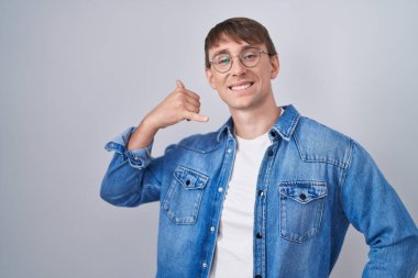 Beyaz, sarışın, gözlüklü, gülümseyen, el ve parmaklarıyla telefonla konuşan bir adam. iletişim kavramları. 