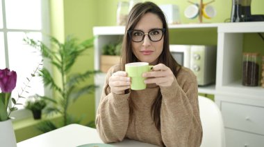 Güzel İspanyol kadın yemek masasında kahve içiyor.