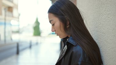 Genç ve güzel İspanyol kadın sokağın karşısında üzgün bir ifadeyle yan tarafa bakıyor.