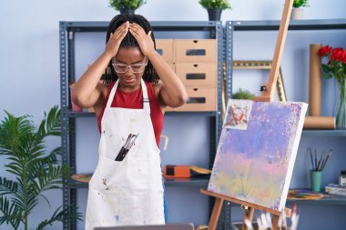 Sanat stüdyosunda saç örgüleriyle resim yapan genç Afrikalı Amerikalı çaresiz ve stresli baş ağrısından muzdarip. Çünkü acı ve migren. Eller başının üstünde.. 