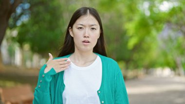 Parkta terleyen genç Çinli kadın.