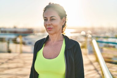 Middle age hispanic woman working out at promenade