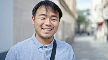  Gülümsüyor, kendine güveniyor.