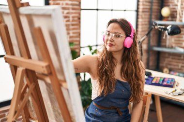 Sanat stüdyosunda müzik dinleyen genç, güzel İspanyol kadın sanatçı.