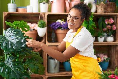 Afro-Amerikan kadın çiçekçi gülümsüyor Çiçekçide kendine güvenen dokunaklı çarşaf