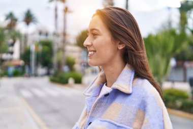 Young beautiful hispanic woman smiling confident looking to the side at street