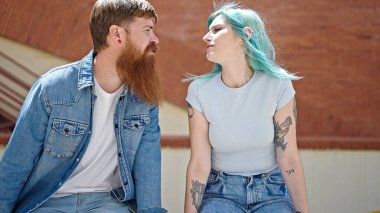 Kadın ve erkek caddede birlikte bankta oturuyorlar.