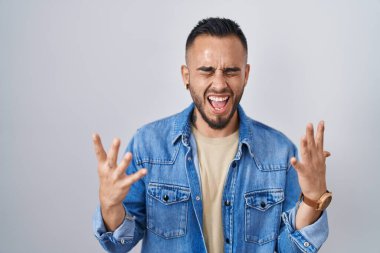 Tecrit edilmiş arka planda duran genç İspanyol adam başarı için deli ve çılgınlığı kutluyor kollarını kaldırmış ve gözlerini kapatmış heyecanla bağırıyor. Kazanan konsept 