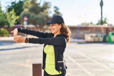 Orta yaşlı İspanyol kadın kollarını dışarı uzatıyor.