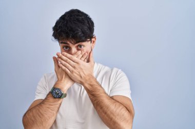 Beyaz arka planda duran İspanyol sakallı adam yanlışlıkla ağızını kapatarak şok geçirdi. gizli kavram. 