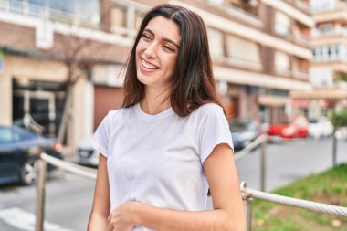 Young beautiful hispanic woman smiling confident looking to the side at street