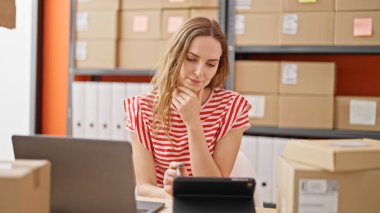 Ofiste dokunmatik ped kullanan genç sarışın bir iş kadını.