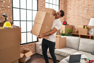 Yeni evinde paketleri tutan İspanyol genç adam.