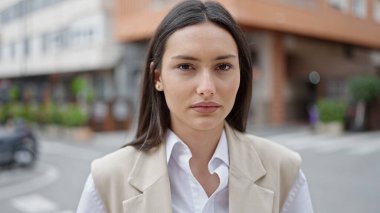 Sokakta ciddi bir ifadeyle duran genç, güzel İspanyol kadın.