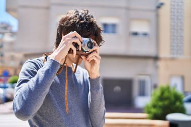 Sokakta klasik kamera kullanan genç bir İspanyol.