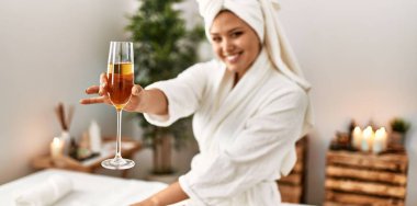 Güzel İspanyol kadın bornoz giyiyor. Güzellik salonunda şampanya içiyor.