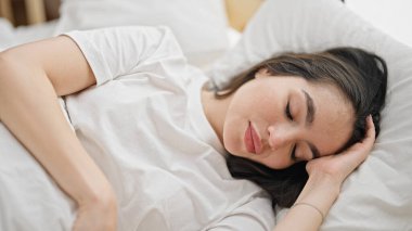 Genç, güzel, İspanyol bir kadın yatakta uzanıyor.