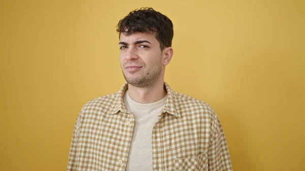 Jovem Hispânico Homem Com Expressão Séria Sobre Fundo Amarelo Isolado — Fotografia de Stock