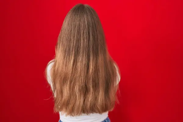 Genç Beyaz Kadın Kırmızı Arka Planda Dikiliyor Arkasını Dönüp Kollarını — Stok fotoğraf