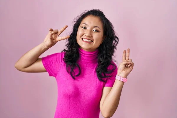 Mladá Asiatka Stojící Nad Růžovým Pozadím Usmívající Vyplazeným Jazykem Ukazujícím — Stock fotografie