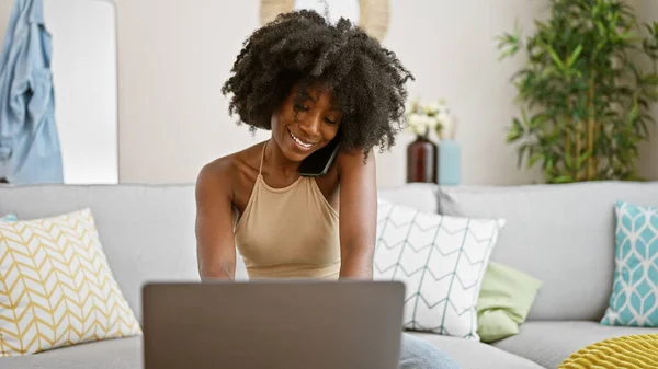 Mujer Afroamericana Hablando Smartphone Usando Laptop Sonriendo Casa —  Fotos de Stock